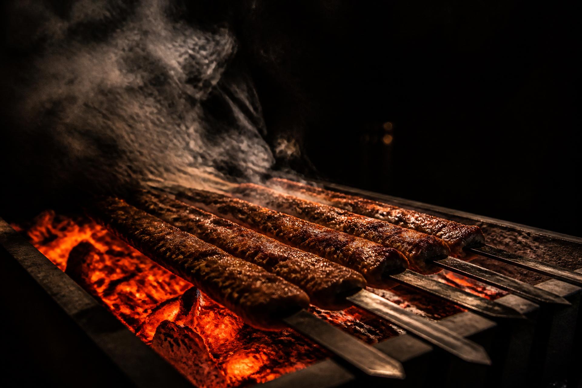 Adana-Spieße über glühender Holzkohle